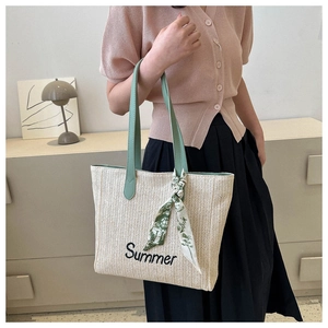 Détail du sac cabas en paille avec broderie Summer et anses en cuir de couleur verte