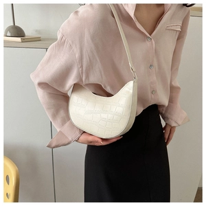 Detail of cream stone pattern baguette bag worn over the shoulder by a model