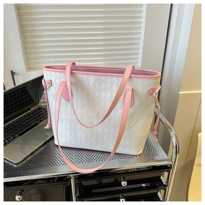 Detail of white quilted tote bag with pink leather handles and side drawstring accents