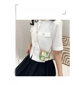 Detail of color-block mini crossbody bag featuring geometric patterns and golden chain strap