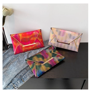 Detailansicht von Umschlag-Clutches mit buntem V-Muster und goldenen Metallelementen