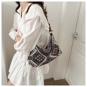 Close-up of bohemian embroidered canvas tote with geometric patterns and leather strap
