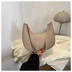 Detailed macro shot of a beige stone-patterned faux leather hobo bag with a crescent shape