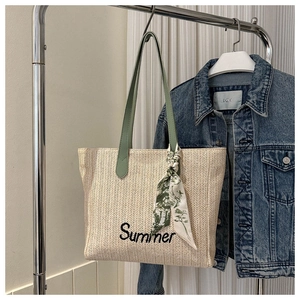 Détail du sac cabas en paille avec broderie Summer, bandoulière verte et foulard en soie