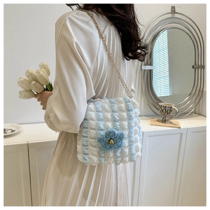 Detail of blue floral puffy tote bag featuring textured bubble fabric and gold chain strap
