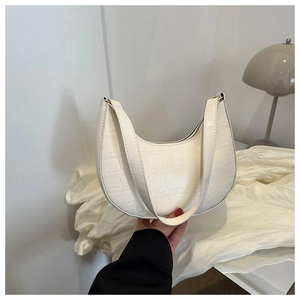Close-up of white crescent shoulder bag featuring premium crocodile embossed texture