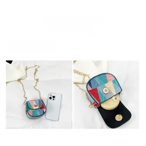 Mini crossbody bag with geometric patchwork and gold chain strap showing internal storage