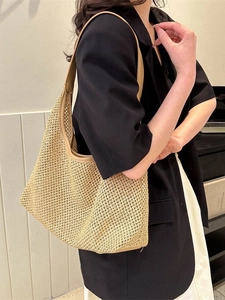 Chic beige straw woven hobo bag with leather trim on model wearing black blazer