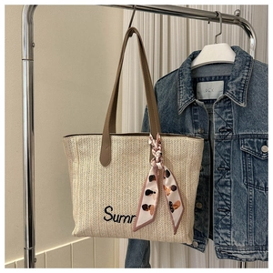 Vue détaillée du sac cabas en paille tissée avec broderie et foulard en soie décoratif