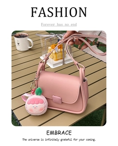 Sac bandoulière rose chic sur table de pique-nique avec pendentif pêche en peluche mignon