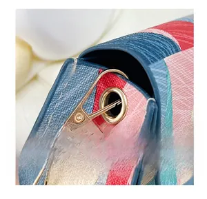 Close-up of golden metal hardware hook and cross-grain leather texture on summer handbag