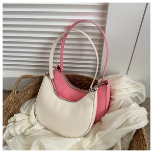 Close-up of cream white and bright pink crescent bags with crocodile pattern in a basket