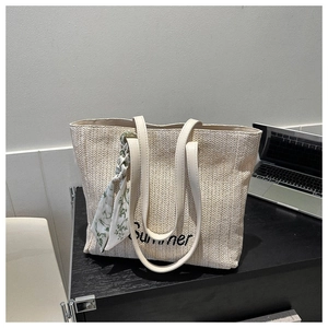 Détail du sac cabas en paille beige avec broderie Summer et foulard à fleurs