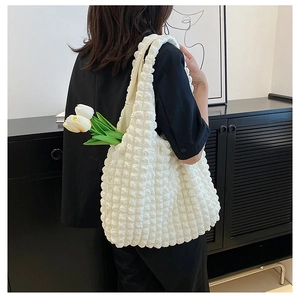 Detailed view of white bubble textured fabric on a large capacity shoulder tote bag