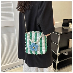Detailed view of striped seersucker tote bag with pearl handle and blue plush flower charm