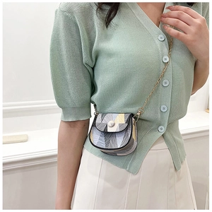 Detail view of mini crossbody bag with colorful geometric patterns and gold chain strap