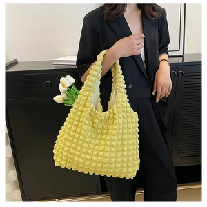 Detail of bright yellow tote bag with unique 3D bubble textured fabric and shoulder strap