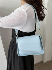 Borsa a tracolla azzurra minimalista con tracolla larga indossata da una modella