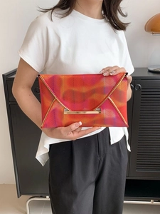 Bunte Chevron-Briefumschlag-Clutch mit goldener Verzierung und lebhaftem Wellenmuster