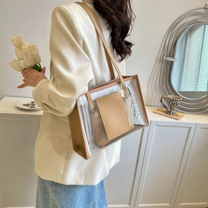 Grand sac fourre-tout transparent en PVC avec bordure en cuir beige porté à l'épaule