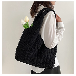 Detail shot of black tote bag with unique popcorn bubble texture and spacious design