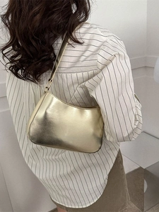 Fashionable golden metallic shoulder bag with a sleek crescent design for women