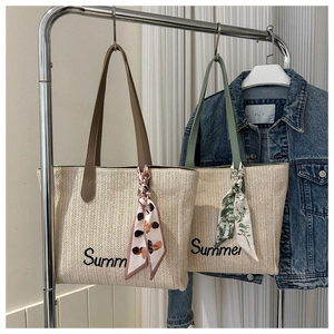 Détail du sac cabas en paille d'été avec broderie et foulards en soie élégants