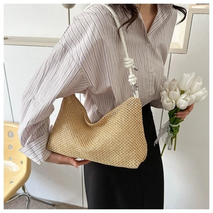 Détail de la texture en paille tressée et bandoulière blanche nouée d'un sac hobo chic