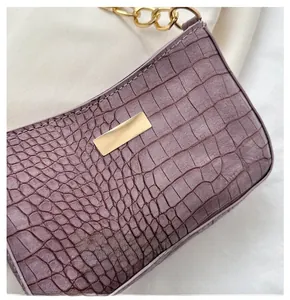 Close-up of light purple crocodile embossed shoulder bag with gold chain strap