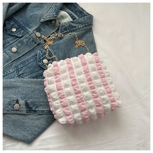 Detail of pink and white striped bubble fabric tote with elegant gold chain strap