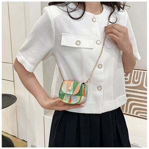 Mini geometric patchwork crossbody bag with gold chain strap worn by a female model