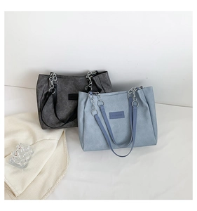 Close-up of minimalist canvas tote bags in dark grey and blue with chain straps
