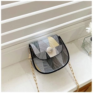 Detail of color-block mini square bag with gold chain strap on white podium