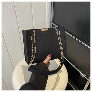 Close-up of black crocodile pattern faux leather texture with elegant gold hardware