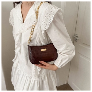 Detail of dark brown faux crocodile shoulder bag with chunky gold chain strap for women