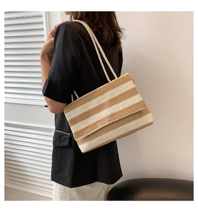 Detail view of large capacity striped woven tote bag showing beige knit texture and shoulder straps