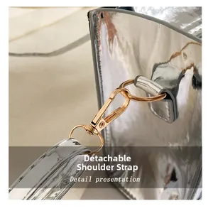 Detail of silver mirror handbag featuring a golden metal hook and detachable shoulder strap