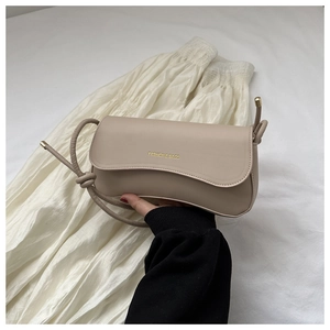 Detail of beige PU leather flap bag with gold FASHION & BAGS lettering and knotted strap