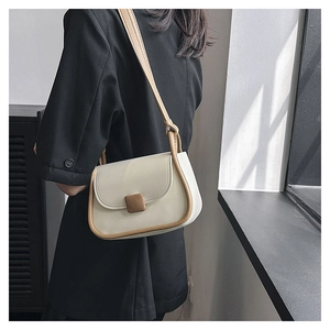 Sac bandoulière en PU blanc crème avec bordure marron contrastée porté par un modèle
