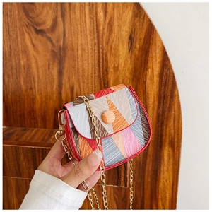 Close-up of geometric color block crossbody bag with woven texture and gold chain strap