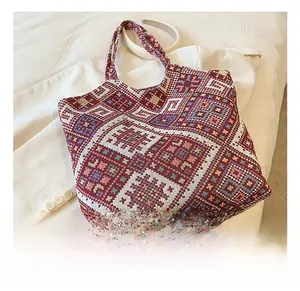 Close-up of geometric jacquard knit tote bag with ethnic pattern in burgundy and blue