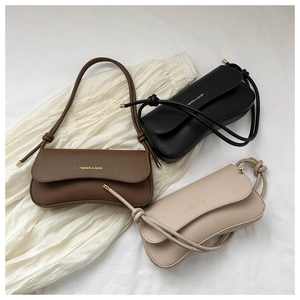 Detailed flat lay of three minimalist shoulder bags in dark brown, black, and apricot colors