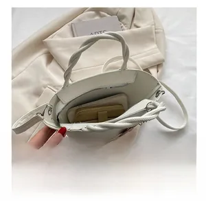 Internal view of white bucket bag showing space for phone and gold zipper wallet