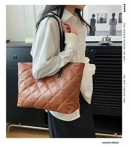Macro view of caramel brown quilted leather tote bag with elegant diamond stitching details