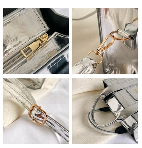 Detail of silver crocodile embossed handbag showing gold hardware and adjustable strap