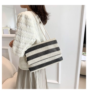 Detail of hand-woven black and white striped tote bag with elegant texture and twin straps