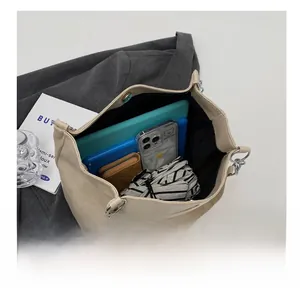 Détails de l'intérieur d'un sac cabas beige montrant une grande capacité pour accessoires