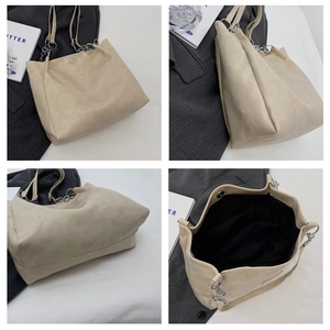 Détails d'un grand sac fourre-tout beige avec chaîne décorative et fermeture magnétique