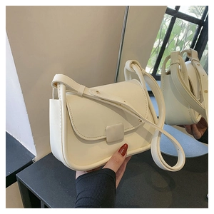 Détail du sac bandoulière blanc crème minimaliste montrant le profil et le reflet du miroir