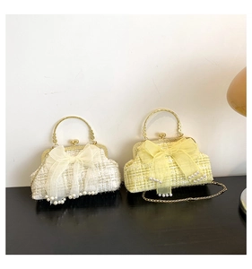 Detail of tweed crossbody bags with oversized organza bows and pearl trim accents